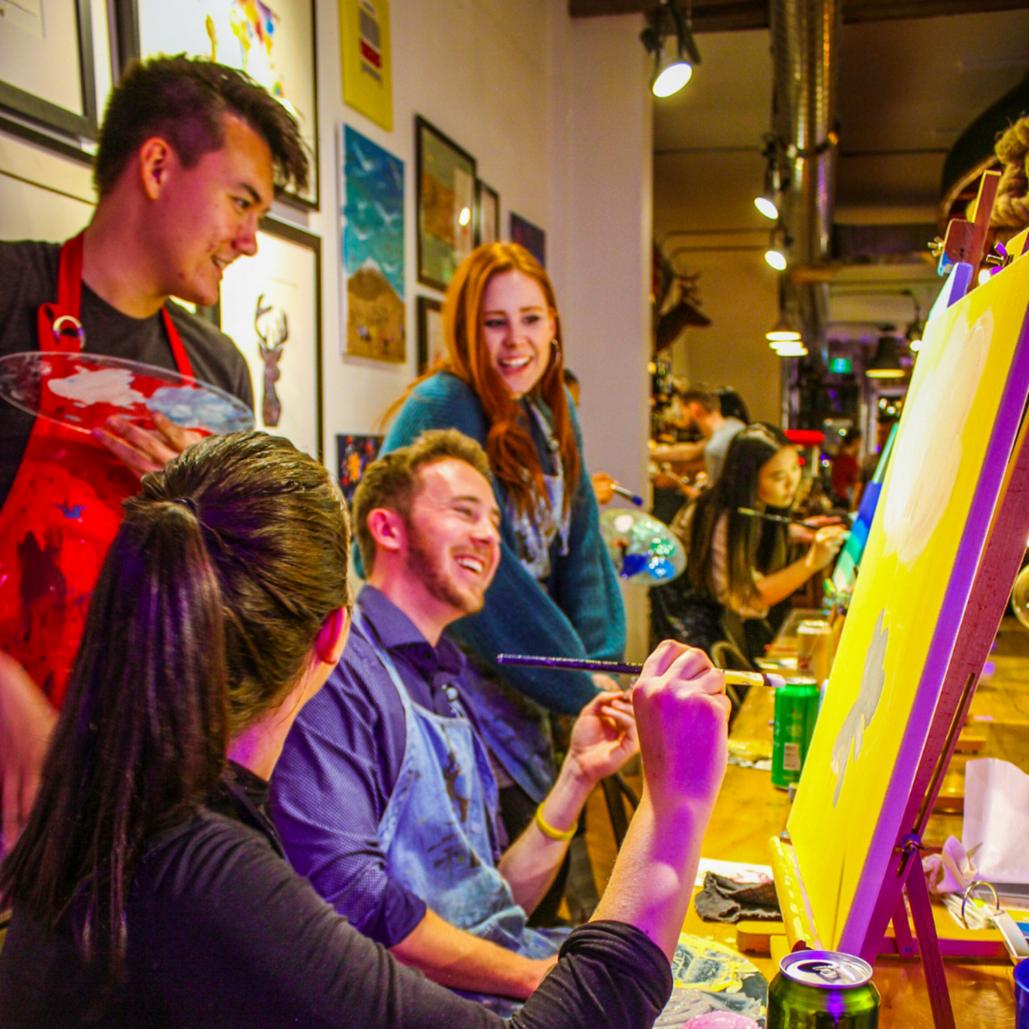 Team laughing and painting during an Employee engagement activity in Toronto with Paint Cabin