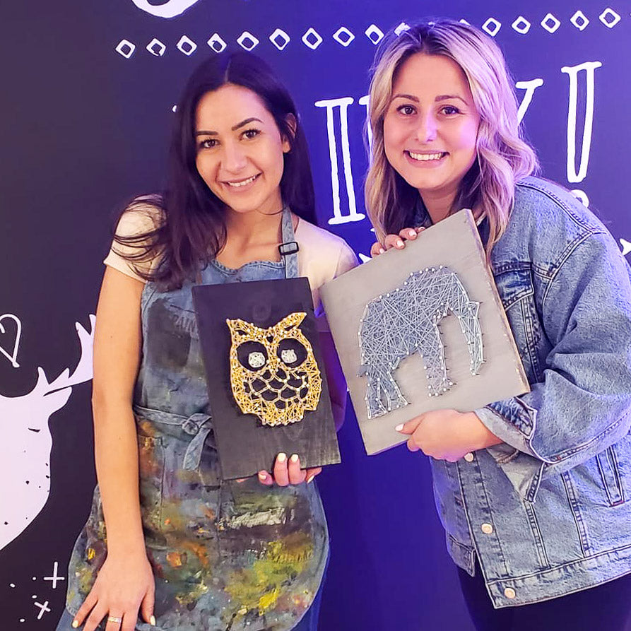 Two smiling participants showcasing their DIY creation at their Corporate Event Party