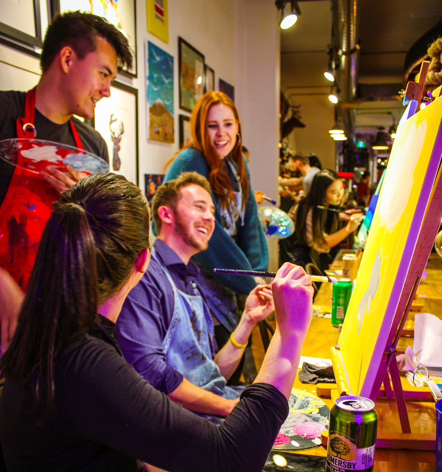 A Group of Participants Laughing and Enjoying a Team Building Activity at Paint Cabin in Toronto with Drinks