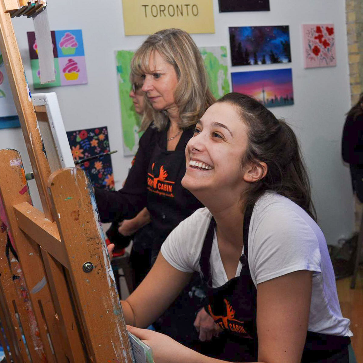 Corporate group laughing during their Paint Night hosted at Paint Cabin 