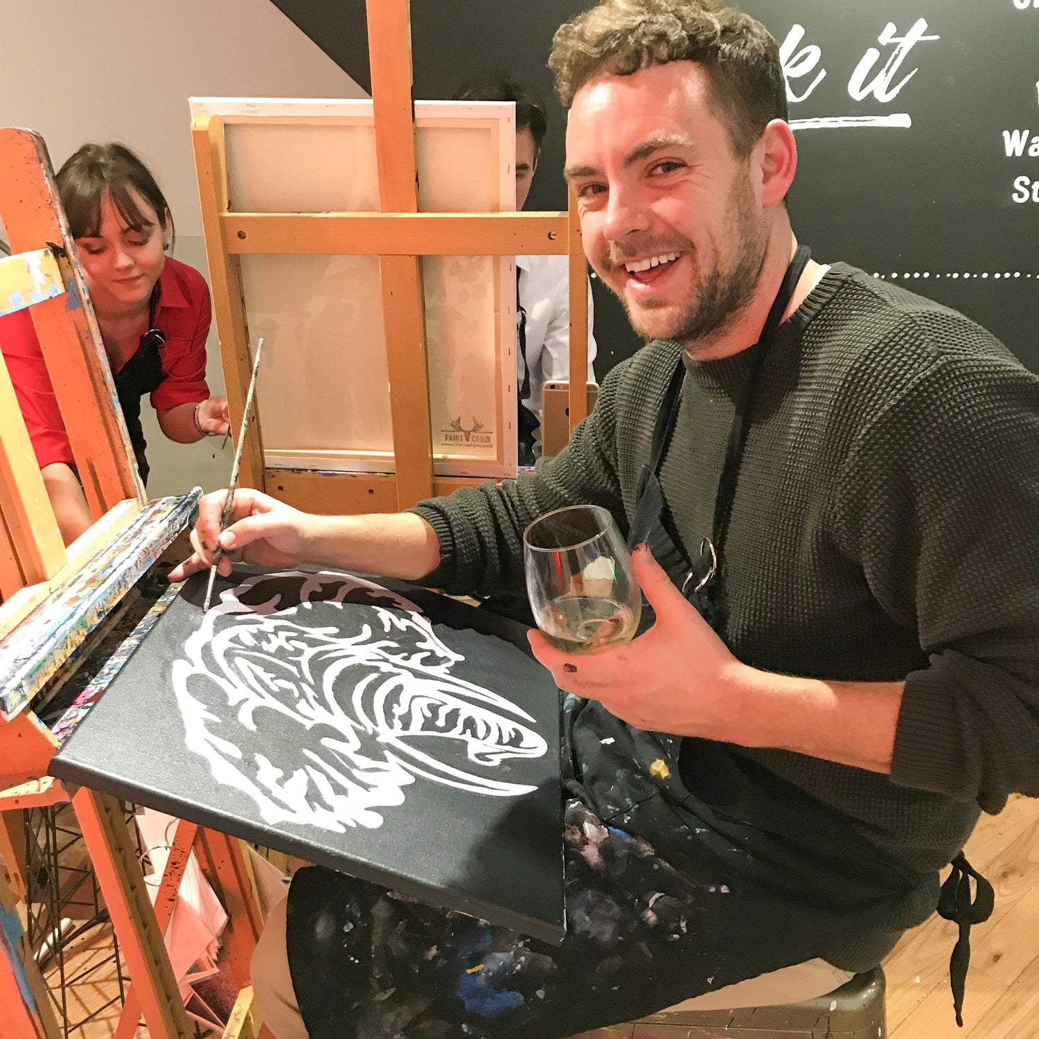 Person holding a wine glass enjoying a paint and drink activity at Paint Cabin in Toronto