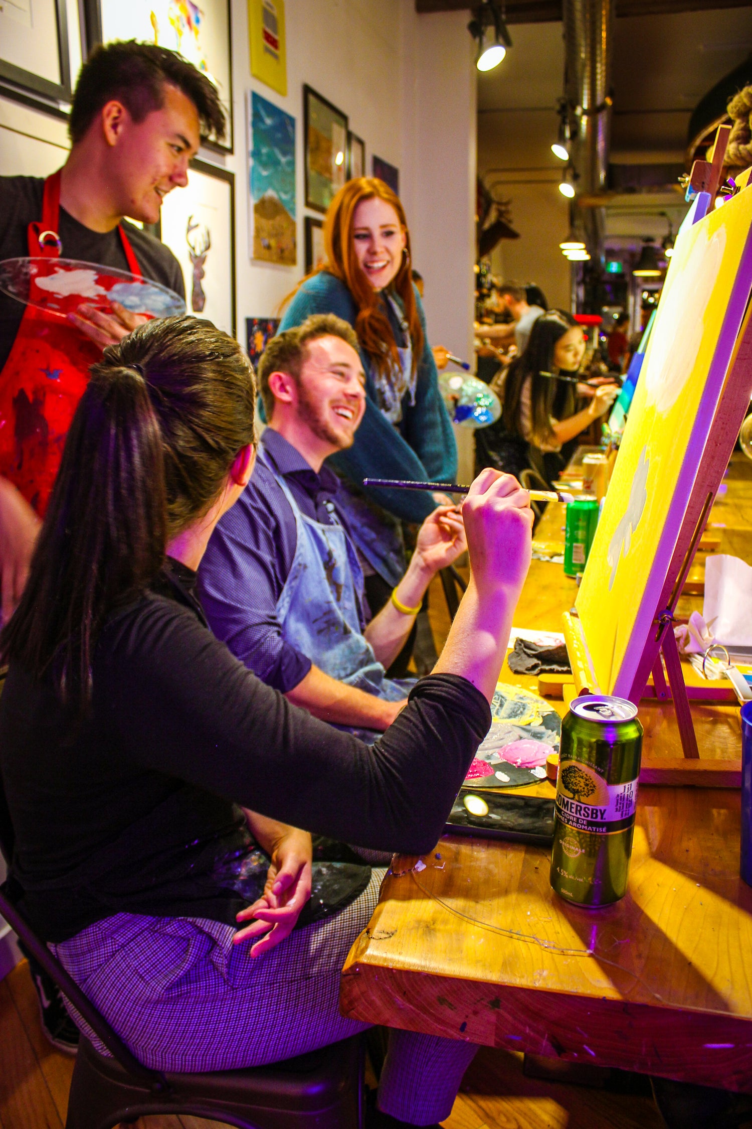 A Group of Participants Laughing and Enjoying a Team Building Activity at Paint Cabin in Toronto with Drinks